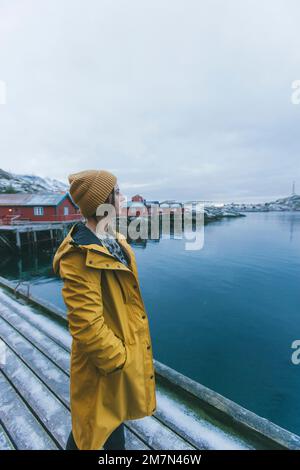 Jeune femme avec imperméable jaune en Norvège, Lofoten, village de pêcheurs Banque D'Images