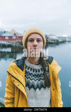 Jeune femme avec imperméable jaune en Norvège, Lofoten, village de pêcheurs Banque D'Images