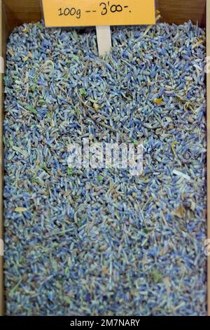 Beaucoup de fleurs séchées de lavande en premier plan à vendre à l'intérieur d'une boîte en bois sur le marché municipal. Banque D'Images