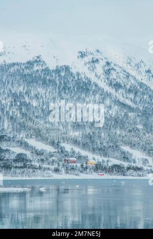 Village de pêcheurs solitaire sur le fjord en Norvège, paysage typique du fjord avec de la neige, isolement du monde extérieur Banque D'Images