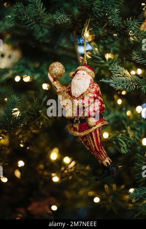 Figurine d'arbre de Noël en forme de Père Noël dans un arbre de Noël éclairé Banque D'Images