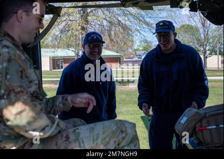 Un pilote de la Garde nationale de l'armée du Connecticut craque une blague avec une paire de gardes-côtes tout en expliquant les capacités de l'UH-60 Black Hawk lors d'un sommet sur les capacités de recherche et de sauvetage au Camp Net à Niantic, CT sur 11 mai 2022. Le sommet a réuni des professionnels de la sécurité publique des États, des collectivités locales et du gouvernement fédéral afin de renforcer l'interopérabilité en matière de recherche et de sauvetage. Banque D'Images