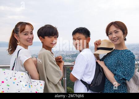 Quatre Japonais sur une sortie, deux femmes matures et deux garçons de 13 ans, de suite, sur une plate-forme de visionnement. Banque D'Images