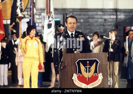 Exigences du commandement aérien tactique le sous-CHEF d'ÉTAT-MAJOR DU MGÉN Carl H. Catey parle aux invités lors de la cérémonie d'arrivée de la flamme olympique alors que le premier porte-flambeau Sandy Norris (costume jaune) écoute. La flamme qui s'est enflammée pour la première fois à Olympia, en Grèce, est transportée dans une série de 52 torchbearers dans une course de relais de 1 000 miles de la base au lac Placid, New York, pour ouvrir les XIII Jeux Olympiques d'hiver. Base: Langley Air Force base État: Virginia (va) pays: Etats-Unis d'Amérique (USA) Banque D'Images