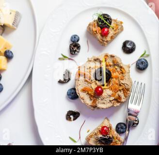 Buffet de banquet. Salade de grenade aux profiteroles farcies et tartelettes dans une assiette isolée sur fond blanc. En-cas pour les fêtes. Banque D'Images