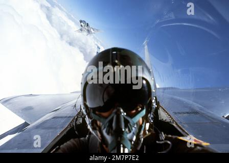 Vue rapprochée d'un arrière-plan d'un avion F-15 Eagle avec un F-4G Phantom II Wild Weasel vu à l'extérieur. Le F-4G est équipé d'un missile anti-radiation AGM-78 standard sur son aile gauche, d'un module de contre-mesures électroniques ALQ-119 sur le côté gauche du fuselage et d'un réservoir de carburant auxiliaire sur l'axe central. L'aéronef appartient au 563rd Escadron d'appui tactique, 35th Escadre d'appui tactique. Base: Nellis Air Force base État: Nevada (NV) pays: États-Unis d'Amérique (USA) Banque D'Images