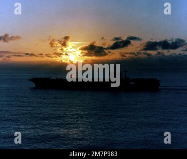 Une vue du porte-avions à propulsion nucléaire USS NIMITZ (CVN 68) silhoueted contre le soleil couchant. Pays : inconnu Banque D'Images