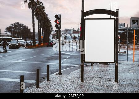 Maquette d'écriteau vierge à côté d'un feu de circulation à côté d'une route large ; un modèle de panneau publicitaire vide dans une petite ville ; une bannière publicitaire blanche plac Banque D'Images