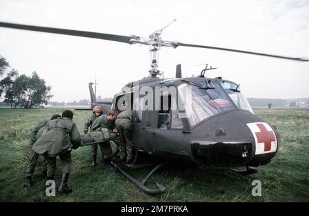 Des aviateurs médicaux chargent un « soldat blessé » à bord d'un hélicoptère un-1N Iroquois du groupe d'évacuation aéromédical 37th pendant l'exercice Reforger '80. Objet opération/série: REFORGER '80 base: Wunstdorf base aérienne allemande pays: Allemagne de l'Ouest (FRG) Banque D'Images