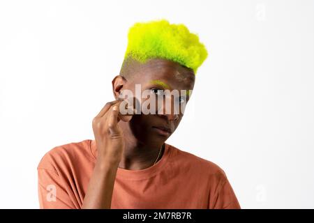 Un homme noir androgyne posant sur le maquillage, concept LGTBI, application de rousseur, fond blanc Banque D'Images