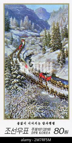 Timbre-poste nord-coréen de 2018 représentant des soldats défilant dans la vallée enneigée de Sobaeksu avec des drapeaux rouges dans un paysage montagneux. Banque D'Images