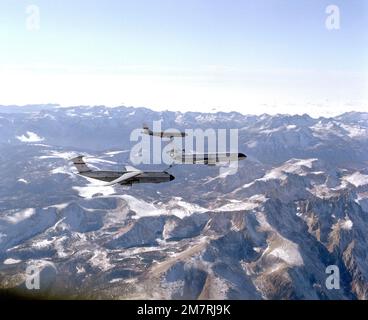 VUE aérienne à droite d'un avion KC-10A Extender ravitaillant un avion C-5A Galaxy, avec un KC-135 Stratotanker en arrière-plan, en vol au-dessus de montagnes enneigées. Pays : inconnu Banque D'Images