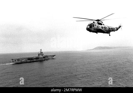 Vue aérienne avant gauche d'un hélicoptère SH-3D Sea King avec le porte-avions USS Ranger (CV 61) visible en arrière-plan. Pays : Océan Pacifique (POC) Banque D'Images