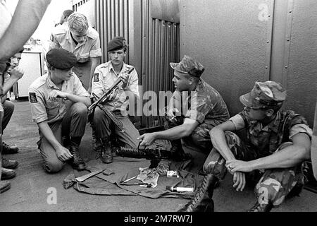 À bord du quai d'atterrissage, USS PLYMOUTH ROCK (LSD-29), Marine PVT de Co K, 3rd BN., 6th Mar., nettoie sa mitrailleuse M-16A1 tandis que trois Marines néerlandaises regardent le groupe d'assemblage du canon. Les Marines se préparent à participer à l'exercice conjoint d'atterrissage amphibie, Unitas XXII. Objet opération/série: UNITAS XXII pays: Océan Atlantique (AOC) Banque D'Images