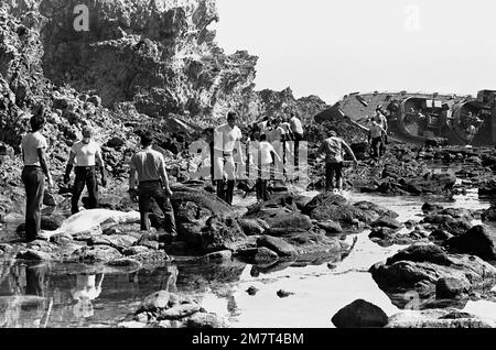 Des membres de l'équipage du navire de munitions USS MOUNT HOOD (AE-29) participent aux opérations de recherche et de sauvetage (SAR) parmi les roches près de la frégate philippine échouée et renversée RPS DATU KAKANTIW (PS-76). La frégate a été dépassée par le typhon Clara. Base: Île de Calayan pays: Philippines Banque D'Images