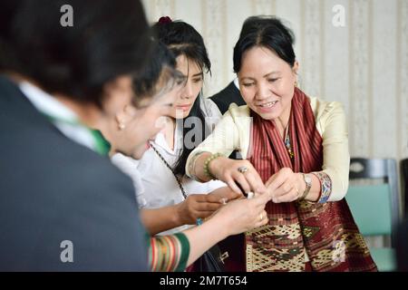 VIENTIANE, 11 janvier 2023 (Xinhua) -- Président de l'Union des femmes lao Inlavanh Keobounphanh (1st R) fait des boulettes avec des anciens de l'école '67' au Centre culturel de Chine à Vientiane, au Laos, 10 janvier 2023. Plus de 50 anciens élèves de l'école '67' ont participé à un événement ici mardi pour célébrer le nouvel an chinois, en disant qu'ils vont toujours chérir l'amitié entre le Laos et la Chine. En 1960s, la Chine a construit l'école '67' à Nanning, la capitale de la région autonome de Guangxi Zhuang, dans le sud de la Chine. L'école porte le nom de l'année 1967, lorsque les deux pays se sont décés Banque D'Images