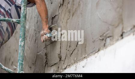 Construction dangereuse de travailleurs migrants du Myanmar tout en plâtant un mur dans le chantier de construction , Thaïlande. Banque D'Images