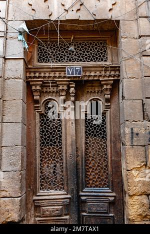 Le Caire, Égypte. 21 décembre 2022 une ancienne porte en bois d'une maison dans les ruelles étroites de la vieille partie du Caire islamique nr Khan el Khalili Bazar, Banque D'Images