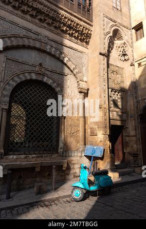 Le Caire, Égypte. 21 décembre 2022 Vespa Motor scooter à l'extérieur de Sabil-Kuttab de Katkhuda, dans la rue Al Muizz nr Khan El Khalili Bazar dans la partie ancienne de Banque D'Images