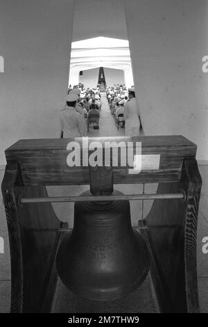 Vue sur l'une des deux cloches utilisées sur le navire de guerre USS ARIZONA (BB-39). La cloche a été placée à l'entrée de l'USS ARIZONA Memorial. En arrière-plan, une cérémonie commémorant le 40th anniversaire de l'attaque japonaise sur Pearl Harbor a lieu. Base: Pearl Harbor État: Hawaï (HI) pays: Etats-Unis d'Amérique (USA) Banque D'Images