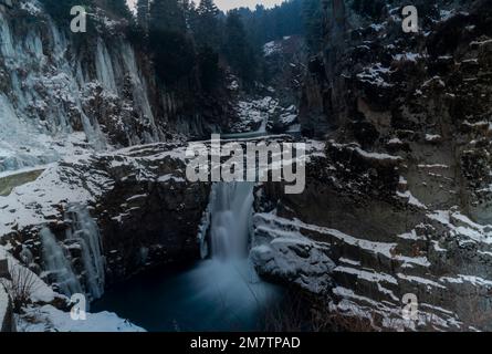 Un long cliché d'exposition d'une chute d'eau partiellement gelée d'Aharbal pendant une journée froide et nuageux à Kulgam. Les eaux de la rivière Veshu créent l'une des chutes d'eau les plus majestueuses connues sous le nom de Aharbal ou Niagara Falls of Kashmir. Les chutes d'eau ont un cadre pittoresque comprenant d'épaisses forêts de sapins, situées au sud de Srinagar. C'est l'une des meilleures destinations touristiques de la vallée du Cachemire. Banque D'Images