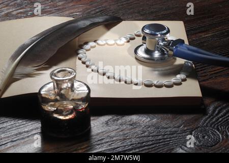 Symbole de coeur disposé à partir de pilules sur un livre et stethoscop. Droit en médecine. Concept de droit médical et de crimes médicaux Banque D'Images