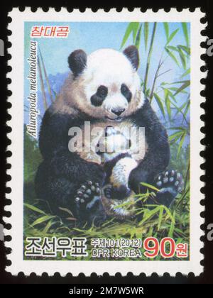 Timbre-poste nord-coréen de 2012 représentant une mère et un petit panda géant, Ailuropoda melanoleuca. Banque D'Images