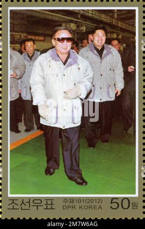 Timbre-poste nord-coréen de 2012 représentant Kim Jong il et Kim Jong un visitant l'usine de machines Heecheon Ryeonha pour des conseils sur le terrain. Banque D'Images
