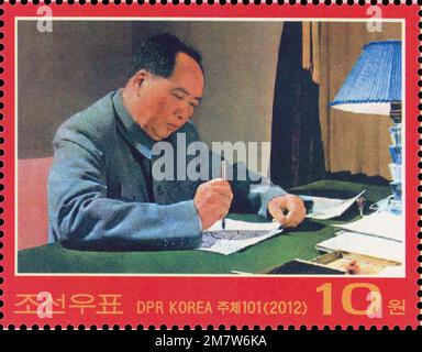 Timbre-poste nord-coréen de 2012 représentant le président Mao Zedong écrivant une calligraphie sur un bureau, célébrant les liens culturels entre la Chine et la Corée du Nord. Banque D'Images