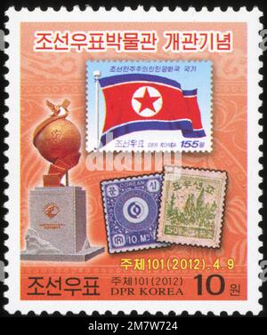Timbre-poste nord-coréen de 2012 commémorant l'ouverture du musée coréen du timbre à Pyongyang, avec le drapeau national et des timbres historiques. Banque D'Images