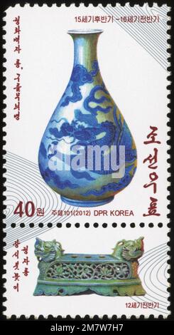 Timbre-poste nord-coréen de 2012 représentant un vase en porcelaine de dragon bleu et blanc et une brosse de dragon en céladon du XIIe siècle. Banque D'Images