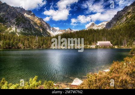 Beau lac et collines paysage de printemps. Tarn Popradske pleso dans les montagnes des Hautes Tatras en Slovaquie Banque D'Images