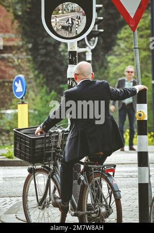 S Hertogenbosch, pays-Bas - 1 avril 2014: Homme d'affaires sur un vélo en face du carrefour à Hertogenbosch ville aux pays-bas Banque D'Images