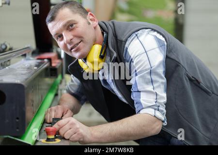 portrait d'un ouvrier d'usine mûr souriant à l'appareil photo Banque D'Images