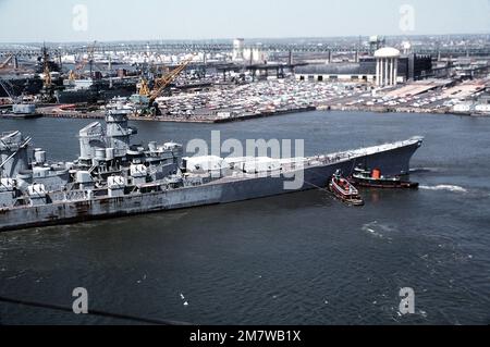 Vue aérienne à tribord du navire DE guerre IOWA (BB-61). L'IOWA est en train d'être déplacé de son amarrage dans le stockage de mothball par des remorqueurs en vue de la modernisation, de la réactivation et de la remise en service en janvier 1985. Base: Philadelphie État: Pennsylvanie (PA) pays: Etats-Unis d'Amérique (USA) Banque D'Images