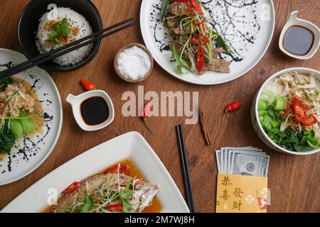 Les aliments à manger à la Saint-Sylvestre lunaire sur la table avec une enveloppe dorée bourrée d'argent comme un signe de bonne fortune pour le nouvel an. Banque D'Images