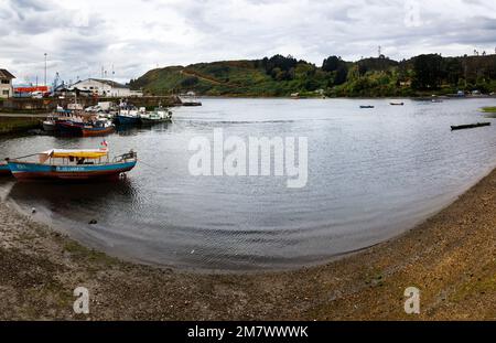 Puerto Montt, Chili-17 octobre 2014: Pêcheurs travaillant sur le quai du petit port avec des pêcheurs et bateau de loisirs à marée haute, à Angelmo, tour Banque D'Images