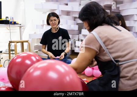 (230111) -- KUALA LUMPUR, le 11 janvier 2023 (Xinhua) -- Syndy Tan Sing Yit (L) et ses collègues travaillent à l'atelier de Tan près de Kuala Lumpur, en Malaisie, le 11 janvier 2023. Syndy Tan Sing Yit est un styliste malaisien de ballons qui travaille sur la modélisation de ballons depuis plus d'une décennie. Elle a créé des sculptures de ballons de danse de lion en se référant à des graphiques et des images de danse de lion. Selon Tan, faire une sculpture de ballon de danse de lion a besoin de plus de 500 ballons, pendant lesquels il est important d'ajuster la couleur des yeux et la proportion des lèvres et le menton afin de mettre en évidence le charme du lion. (Xinh Banque D'Images