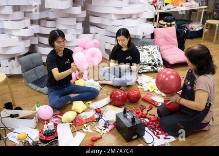 (230111) -- KUALA LUMPUR, le 11 janvier 2023 (Xinhua) -- Syndy Tan Sing Yit (L) et ses collègues travaillent à l'atelier de Tan près de Kuala Lumpur, en Malaisie, le 11 janvier 2023. Syndy Tan Sing Yit est un styliste malaisien de ballons qui travaille sur la modélisation de ballons depuis plus d'une décennie. Elle a créé des sculptures de ballons de danse de lion en se référant à des graphiques et des images de danse de lion. Selon Tan, faire une sculpture de ballon de danse de lion a besoin de plus de 500 ballons, pendant lesquels il est important d'ajuster la couleur des yeux et la proportion des lèvres et le menton afin de mettre en évidence le charme du lion. (Xinh Banque D'Images