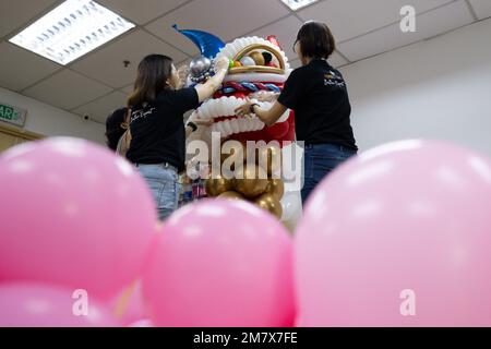 (230111) -- KUALA LUMPUR, le 11 janvier 2023 (Xinhua) -- Syndy Tan Sing Yit (R) et ses collègues ont poli un ballon de danse du lion dans son atelier près de Kuala Lumpur, en Malaisie, le 11 janvier 2023. Syndy Tan Sing Yit est un styliste malaisien de ballons qui travaille sur la modélisation de ballons depuis plus d'une décennie. Elle a créé des sculptures de ballons de danse de lion en se référant à des graphiques et des images de danse de lion. Selon Tan, faire une sculpture de ballon de danse de lion a besoin de plus de 500 ballons, au cours de laquelle il est important d'ajuster la couleur des yeux et la proportion des lèvres et du menton pour highlig Banque D'Images