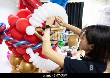 (230111) -- KUALA LUMPUR, le 11 janvier 2023 (Xinhua) -- Syndy Tan Sing Yit ajuste une sculpture en ballon de danse du lion dans son atelier près de Kuala Lumpur, en Malaisie, le 11 janvier 2023. Syndy Tan Sing Yit est un styliste malaisien de ballons qui travaille sur la modélisation de ballons depuis plus d'une décennie. Elle a créé des sculptures de ballons de danse de lion en se référant à des graphiques et des images de danse de lion. Selon Tan, faire une sculpture de ballon de danse de lion a besoin de plus de 500 ballons, pendant lesquels il est important d'ajuster la couleur des yeux et la proportion des lèvres et le menton afin de mettre en évidence le charme du li Banque D'Images