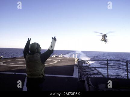 Un crewman de plate-forme de vol signale un hélicoptère (LAMPES) polyvalent aéroporté à la lumière du SH-2F Seasprite à l'atterrissage sur un navire Unitas XXI. L'hélicoptère est relié à l'Escadron 34 (HAL-34) anti-sous-marin de l'hélicoptère léger. Objet opération/série : UNITAS XXI pays : Océan Pacifique (POC) Banque D'Images