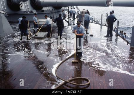 Des hommes de guerre frayent le pont à bord du cuirassé USS NEW JERSEY (BB 62). Le NEW JERSEY, après avoir récemment terminé ses travaux de rénovation et de modernisation, fait l'objet d'essais en mer avant sa réactivation en janvier 1983. Pays : Océan Pacifique (POC) Banque D'Images