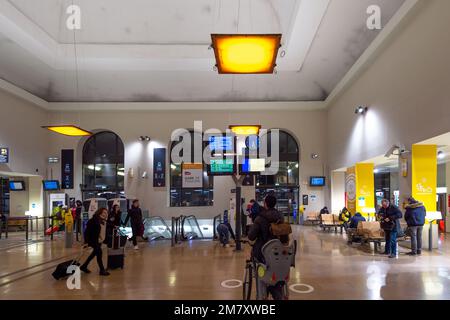 Les passagers passent devant les panneaux lumineux dans le hall de la gare de Toulon (Var) au crépuscule. Depuis le jeudi 5 janvier 2023, un nouveau système de tarification des transports administré par la région Provence-Alpes-Côte d'Azur est en vigueur. L'autorité régionale gère les bus Zou et les trains express régionaux (TER). Certains utilisateurs dénoncent une augmentation globale des tarifs. Dans le même temps, la région du Sud annonce un important projet de réorganisation ferroviaire avec la création de la nouvelle ligne ferroviaire PACA et une augmentation de la fréquence du TER (trains Express Regionaux). (Photo de la Banque D'Images