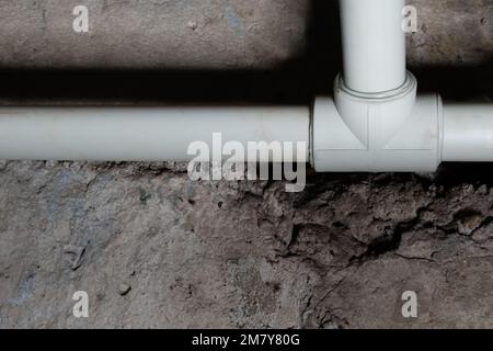 Communication de plomberie sur fond flou de ténèbres dans le sous-sol de la maison avec éclairage local Banque D'Images