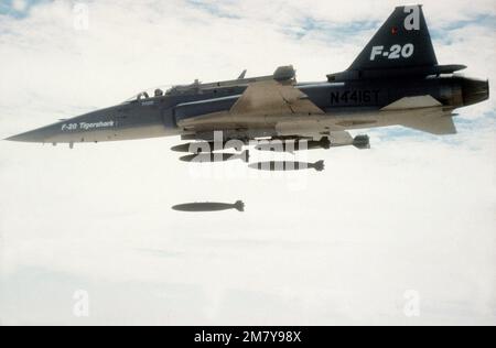 Vue aérienne à gauche d'un Tigershar F-20 de Northrop qui largue des bombes d'entraînement au cours d'une démonstration. L'avion est armé de missiles AIM-9 Sidewinder. Base: Edwards Air Force base État: Californie (CA) pays: États-Unis d'Amérique (USA) Banque D'Images