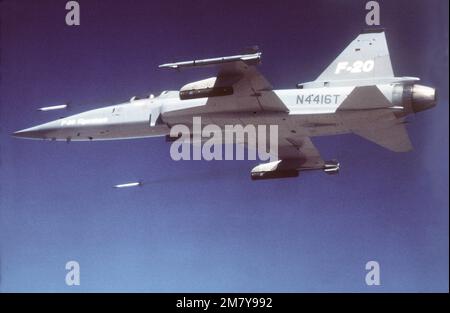 Vue aérienne à gauche d'un avion F-20 Tigershar Northrop tirant des roquettes au cours d'une démonstration. L'avion est armé de missiles AIM-9 Sidewinder. Base: Edwards Air Force base État: Californie (CA) pays: États-Unis d'Amérique (USA) Banque D'Images