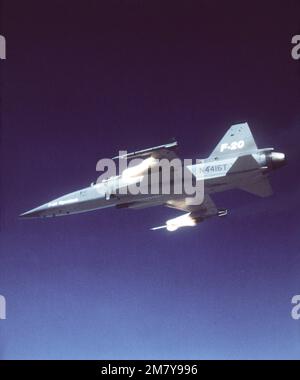 Vue aérienne à gauche d'un avion F-20 Tigershar Northrop tirant des roquettes au cours d'une démonstration. L'avion est armé de missiles AIM-9 Sidewinder. Base: Edwards Air Force base État: Californie (CA) pays: États-Unis d'Amérique (USA) Banque D'Images