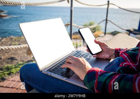 Gros plan des mains de la fille en utilisant l'ordinateur et le smartphone, écrans mockup Banque D'Images