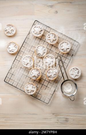 Plat déposer les tartes à la menthe recouvertes d'étoiles de pâtisserie, saupoudrées de sucre glace sur fond de bois blanc: Cuisson maison de Noël. Banque D'Images